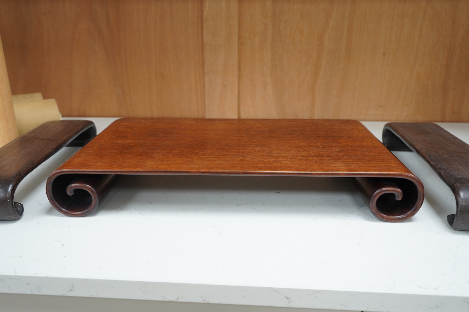 A 19th century Chinese padouk wood scholar’s scroll end stand and two similar hongmu stands, largest 45cm wide. Condition - good